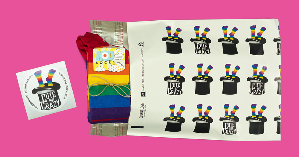 Rainbow-striped ModSocks brand knee socks are packaged for shipment in a Cute But Crazy Socks poly mailer, made from 100% recycled and 100% recyclable materials, along with a zero-waste logo sticker.