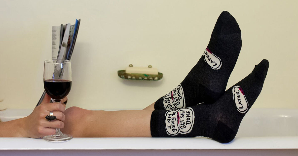 Procrastinating while wearing funny socks that say, "I am going to get shit done later"