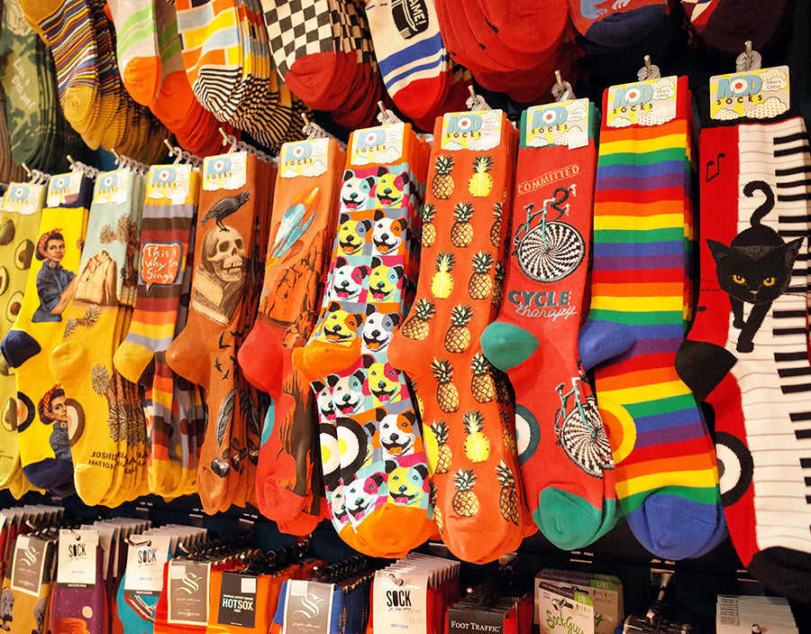 Rows of fun novelty crew socks arranged by color at Cute But Crazy Socks in Bellingham, Washington. 
