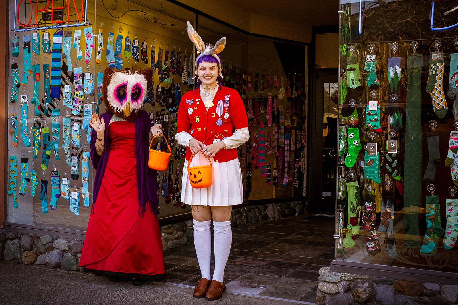 Two employees dressed in Halloween costumes — an owl and the White Rabbit — stand outside of Cute But Crazy Socks, formerly known as ModSock, a sock store in Bellingham, Washington.