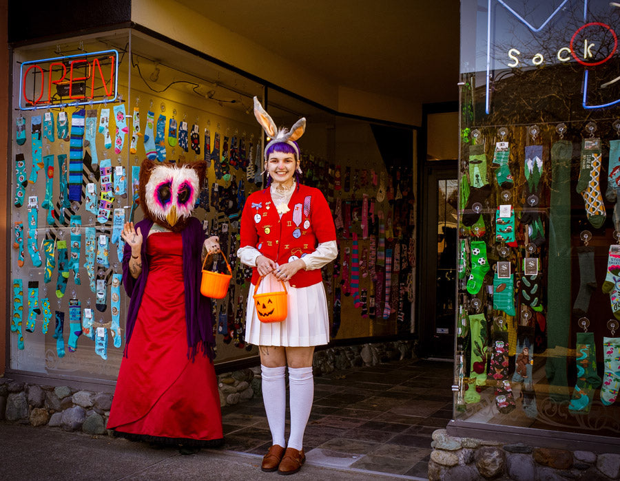 Two employees dressed in Halloween costumes — an owl and the White Rabbit — stand outside of Cute But Crazy Socks, formerly known as ModSock, a sock store in Bellingham, Washington.