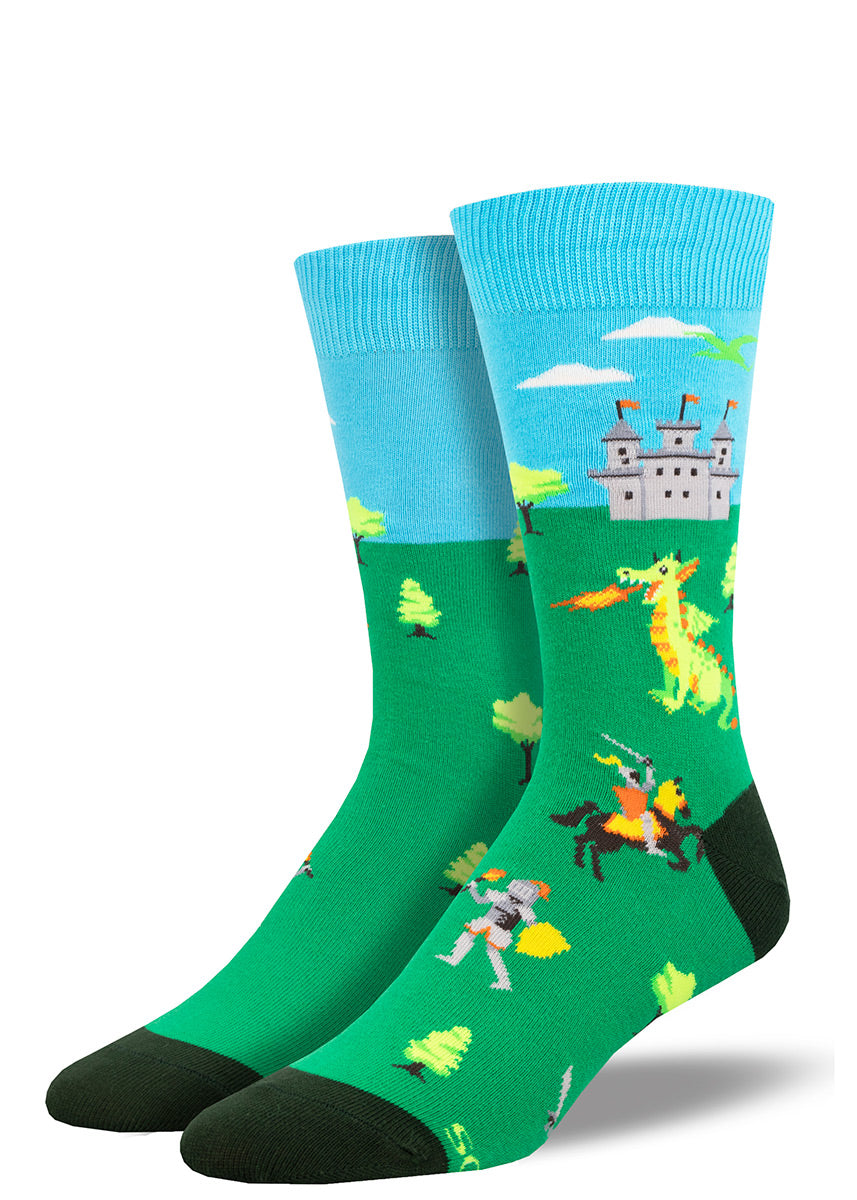 Green and blue novelty socks for men depicting a medieval scene including a castle, a dragon breathing fire, and knights.