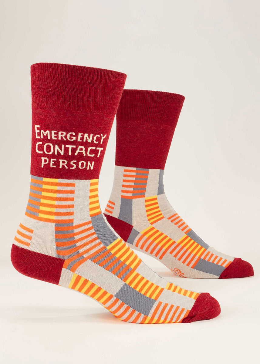 Red crew socks for men that say "Emergency Contact Person" on them and feature a repeating geometric stripe pattern.