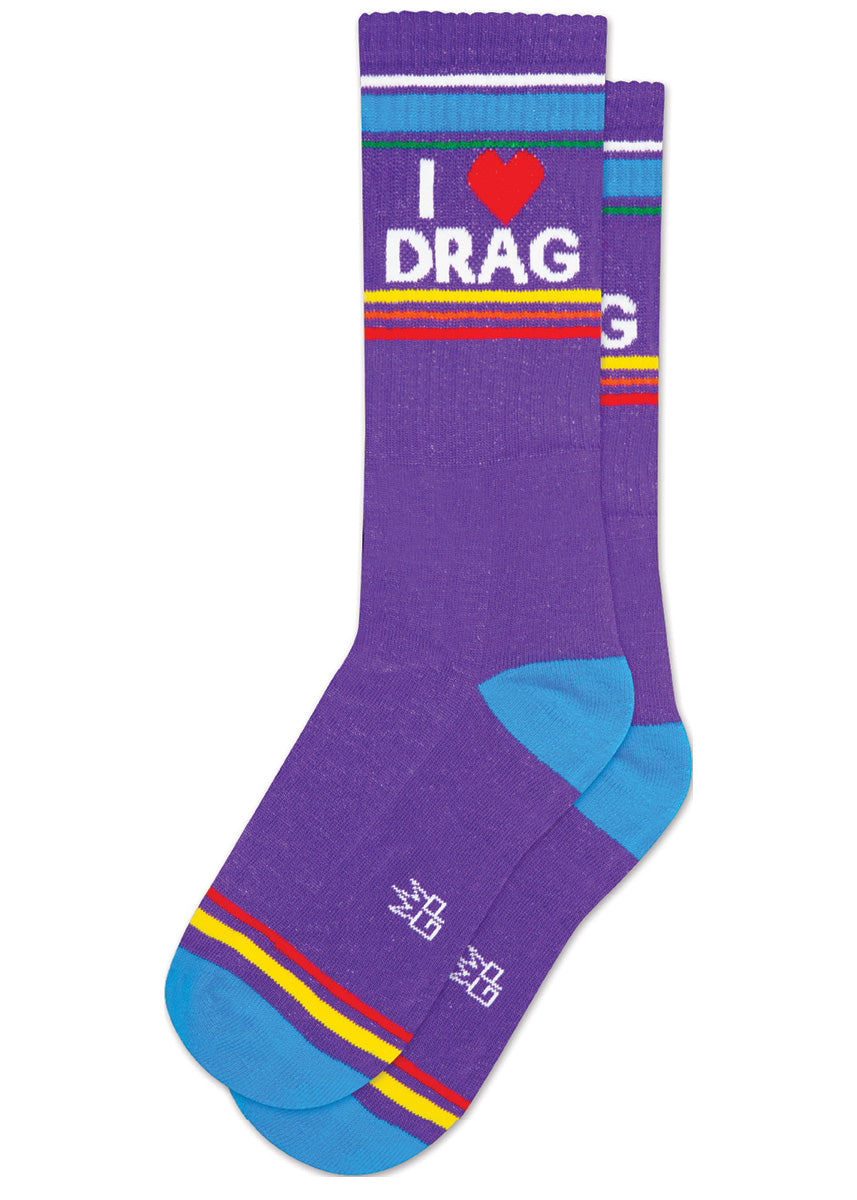 Purple retro-style striped gym socks say “I ❤️ DRAG,&quot; accented with colorful rainbow stripes and blue at the heel and toe.