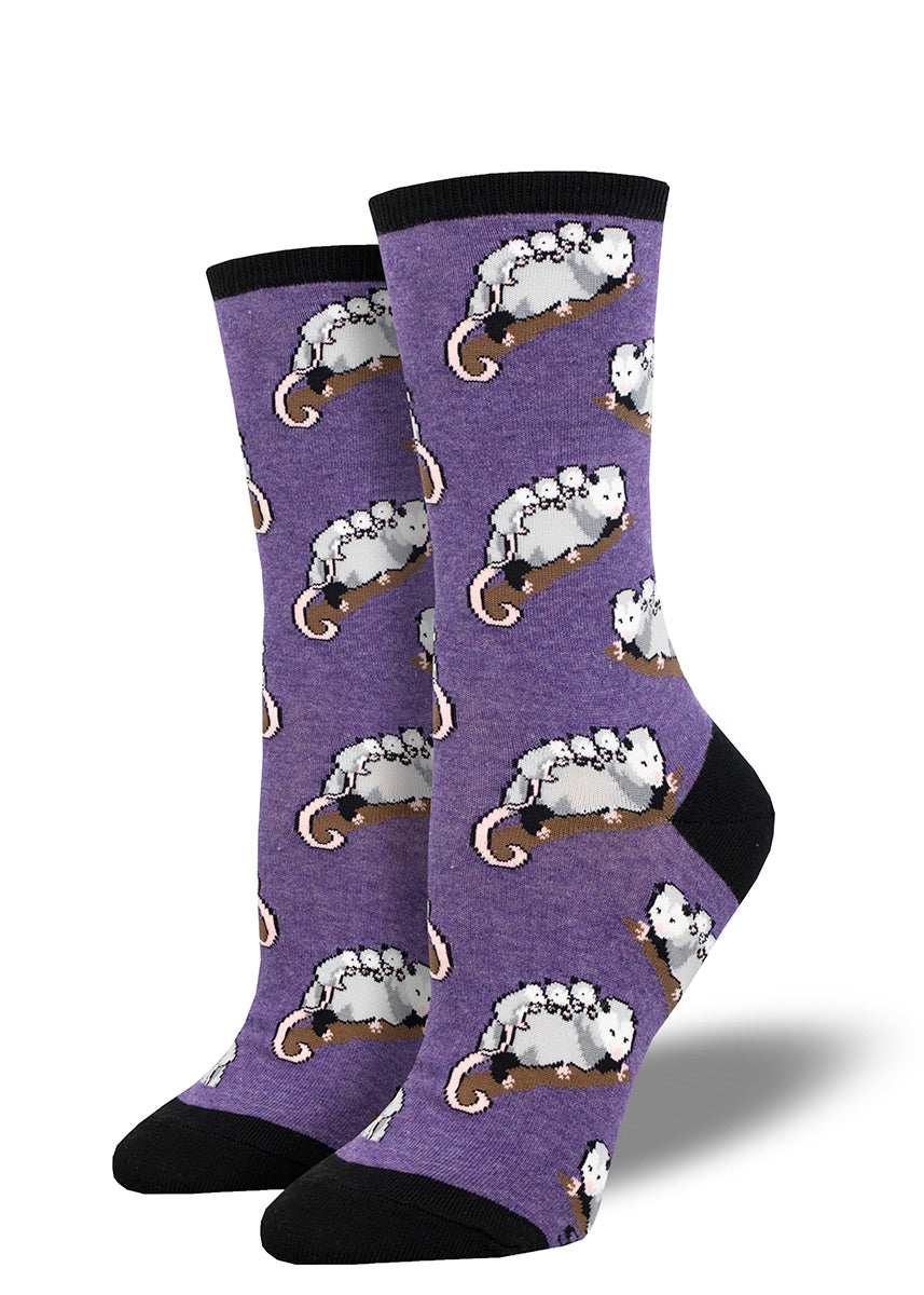 Little opossum babies ride on their mother&#39;s back in an allover repeating pattern on these violet novelty crew socks for women. 