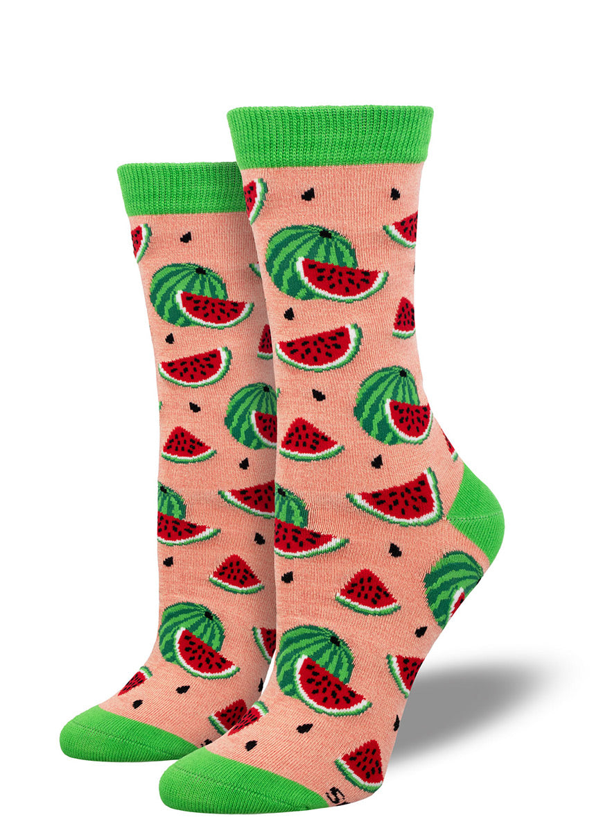 Pink crew socks for women with an allover pattern of watermelons, watermelon slices, and black watermelon seeds.