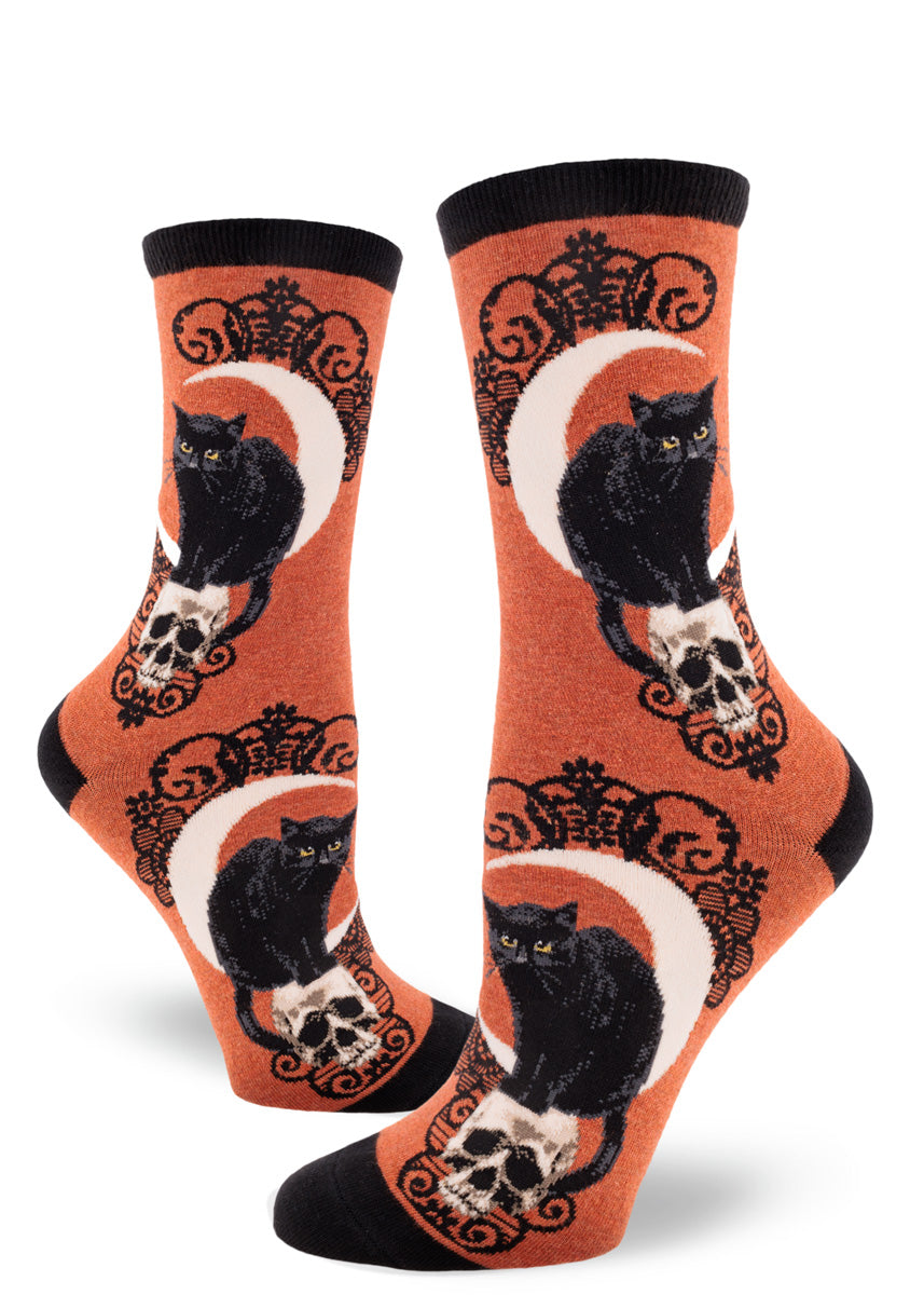 Heather sienna crew socks with a design of black cats, crescent moons and skulls accented with a black lace pattern.