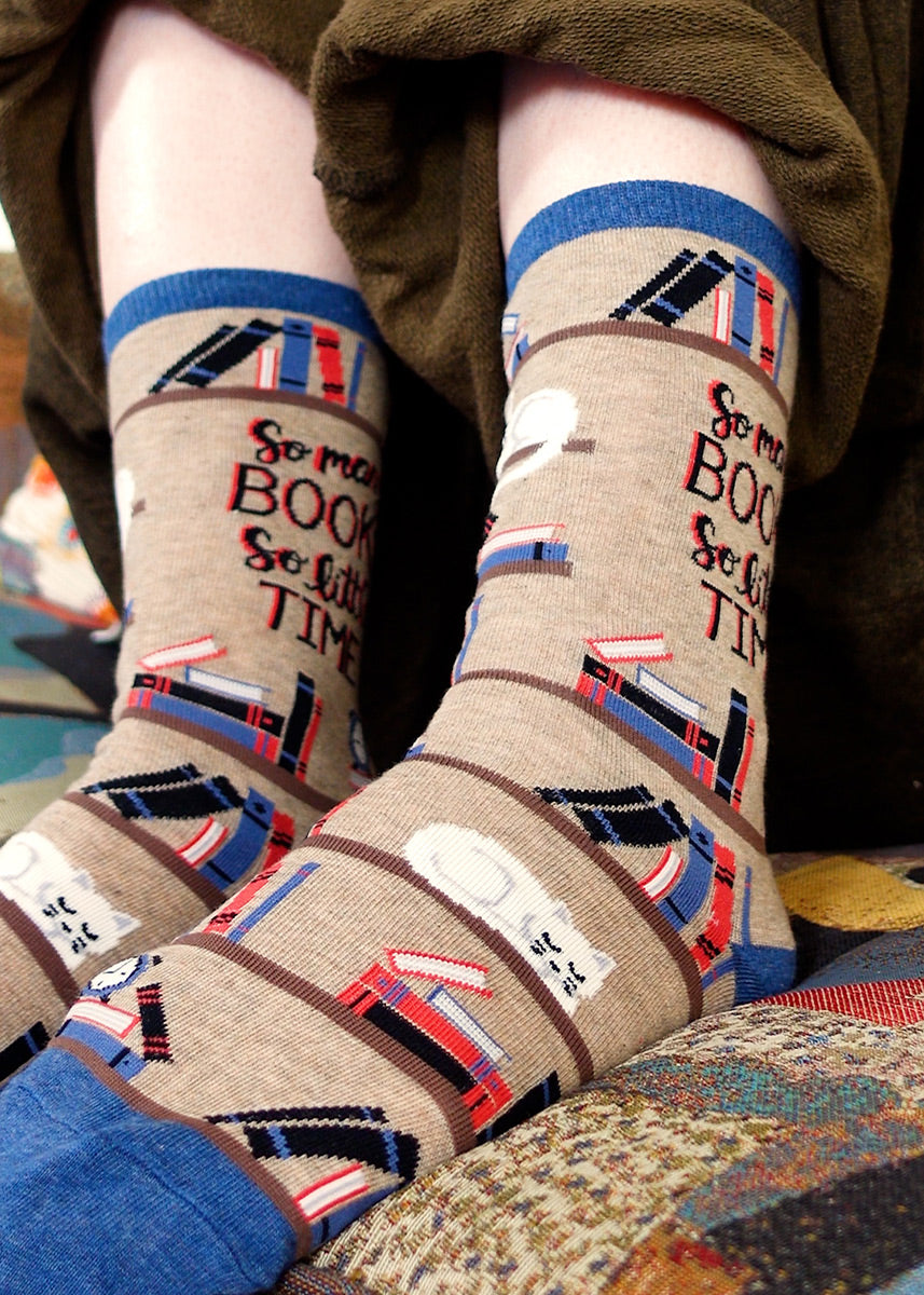 Cute book socks for women with bookshelves, a cat and the words "So many books, so little time"