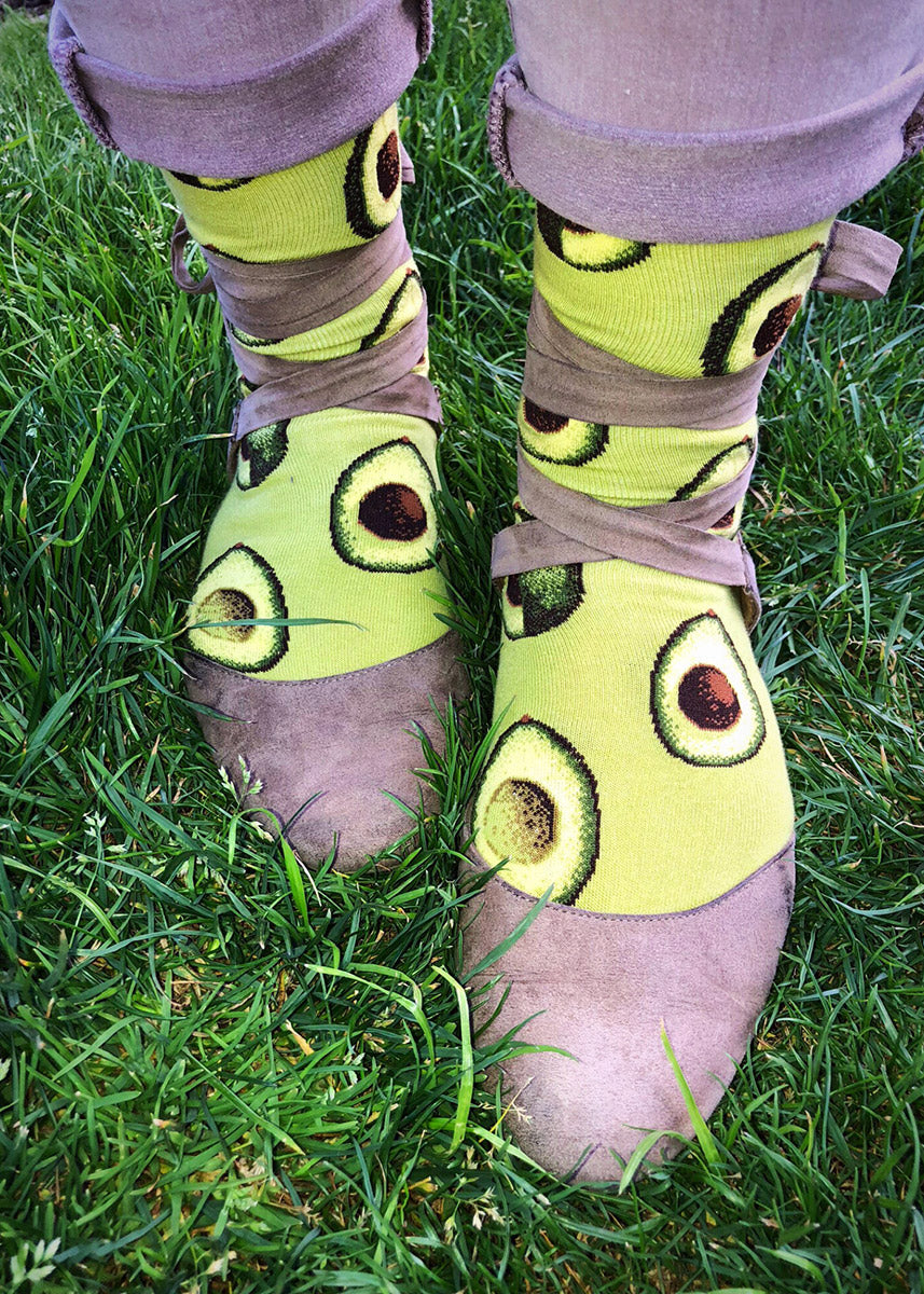 Cute avocado socks for women with avocados sliced open on a green background