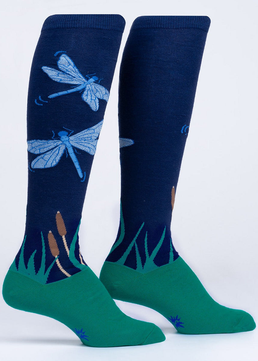 Nature knee socks feature sparkly light blue dragonflies flying over green grass under a dark blue night sky.
