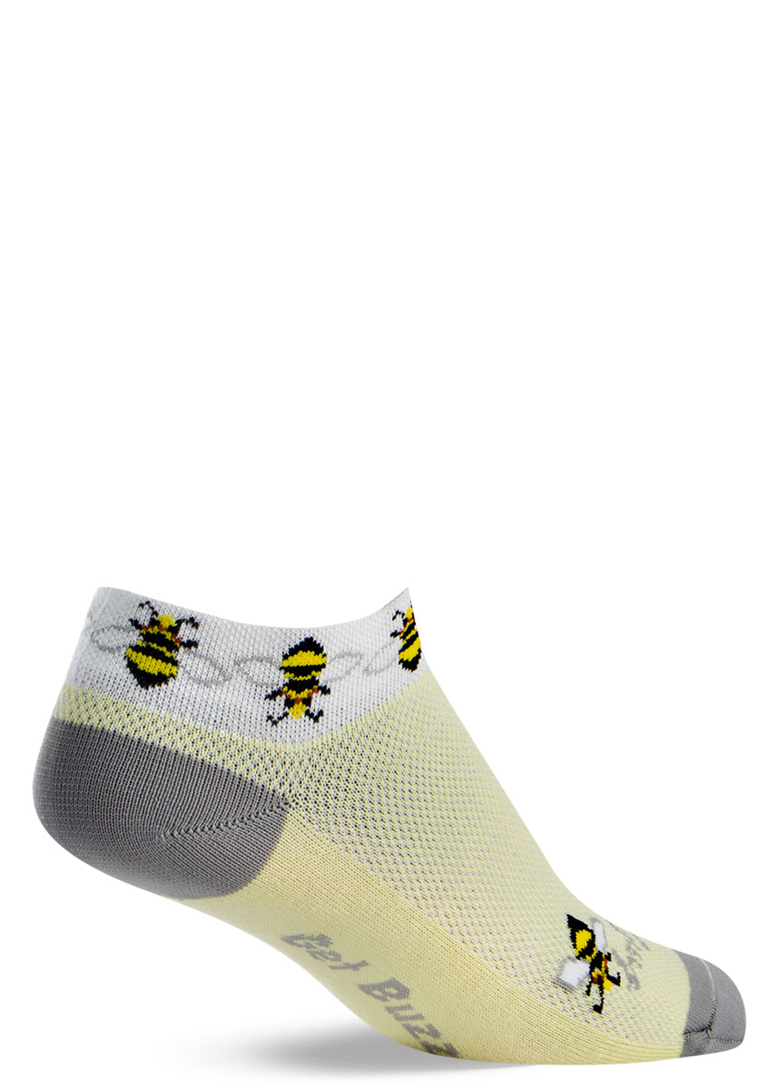 Cute bee ankle socks for women with honeybees on light yellow socks with the words &quot;Get buzzy&quot; on the bottoms of the feet
