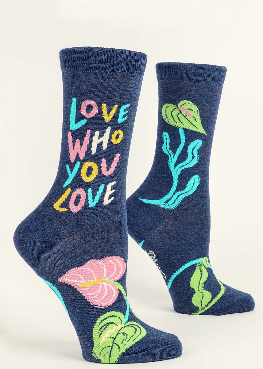 Crew socks for women say &quot;Love who you love&quot; in colorful pastel letters with an abstract floral design.