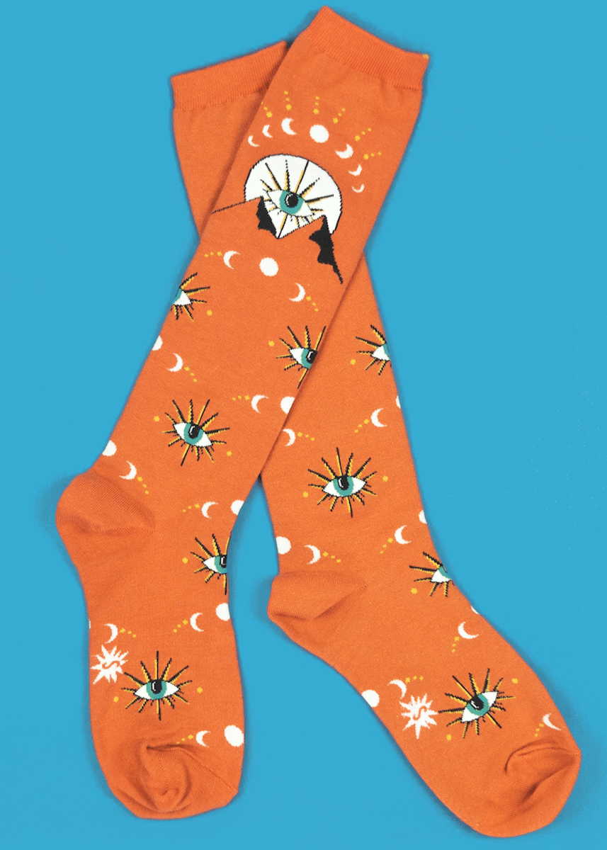 Knee high socks feature glow-in-the-dark crescent and full moons above a mystic all-seeing mountain.