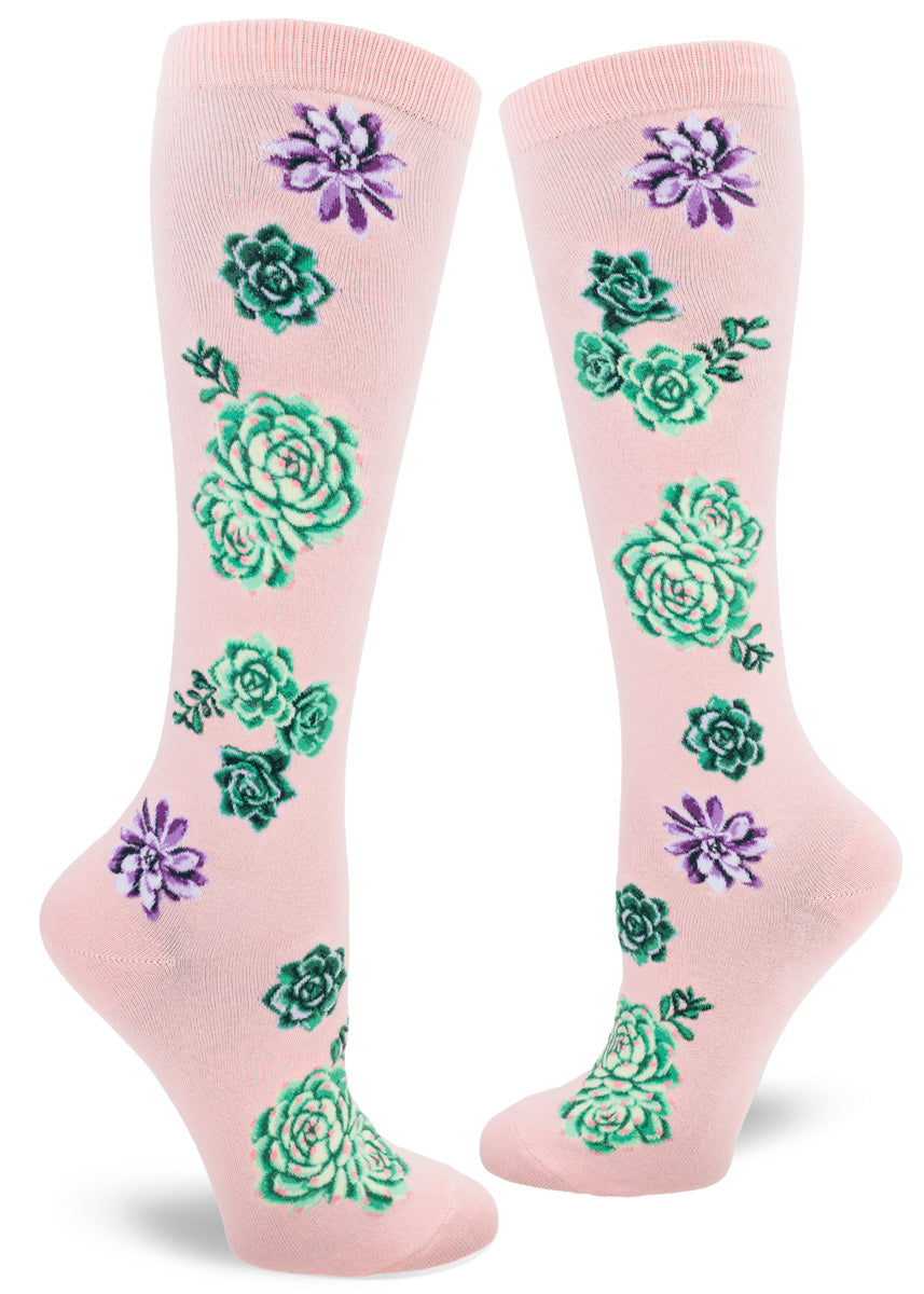 Pastel pink knee socks with a succulent plants design rendered in shades of purple, green and pink.