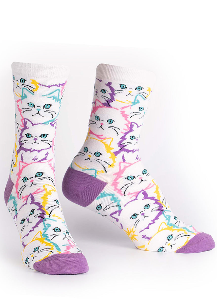 White cat faces outlined in pastel colors on women&#39;s crew socks.