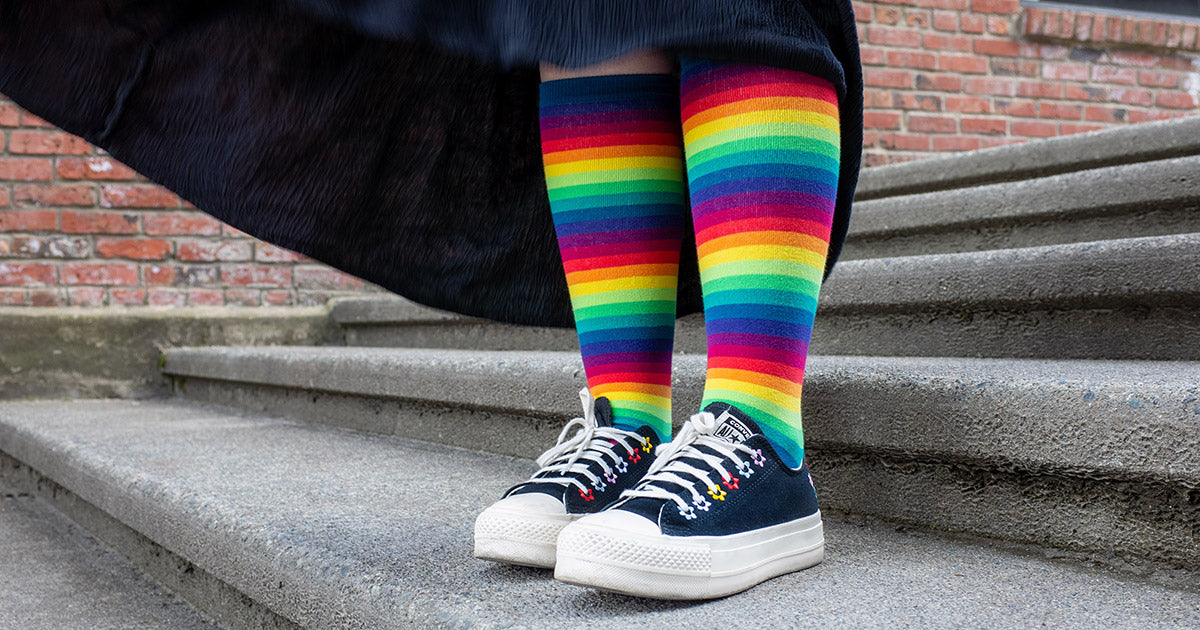 Rainbow gradient knee socks worn with black Converse 