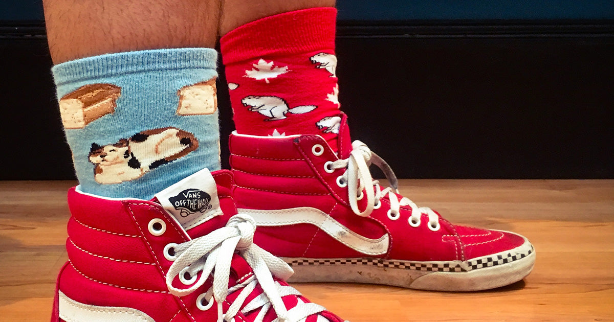 Two feet wearing mismatched socks with cats and beavers for Crazy Sock Day