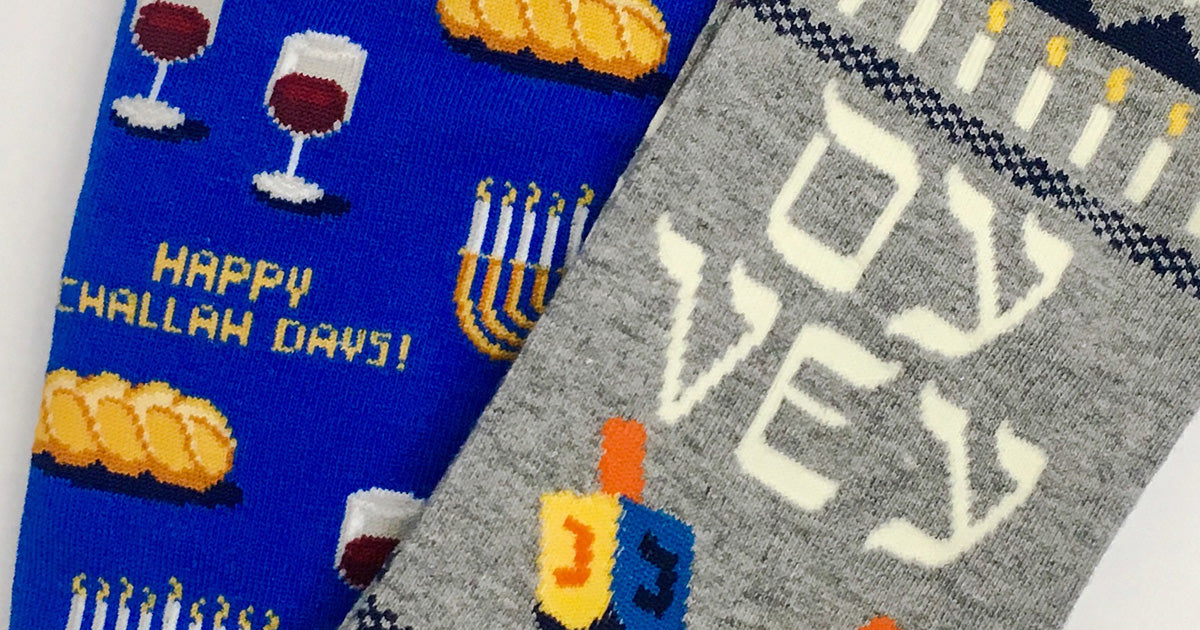 Hanukkah socks with challah bread, a menorah, a dreidel and the words "Oy vey."