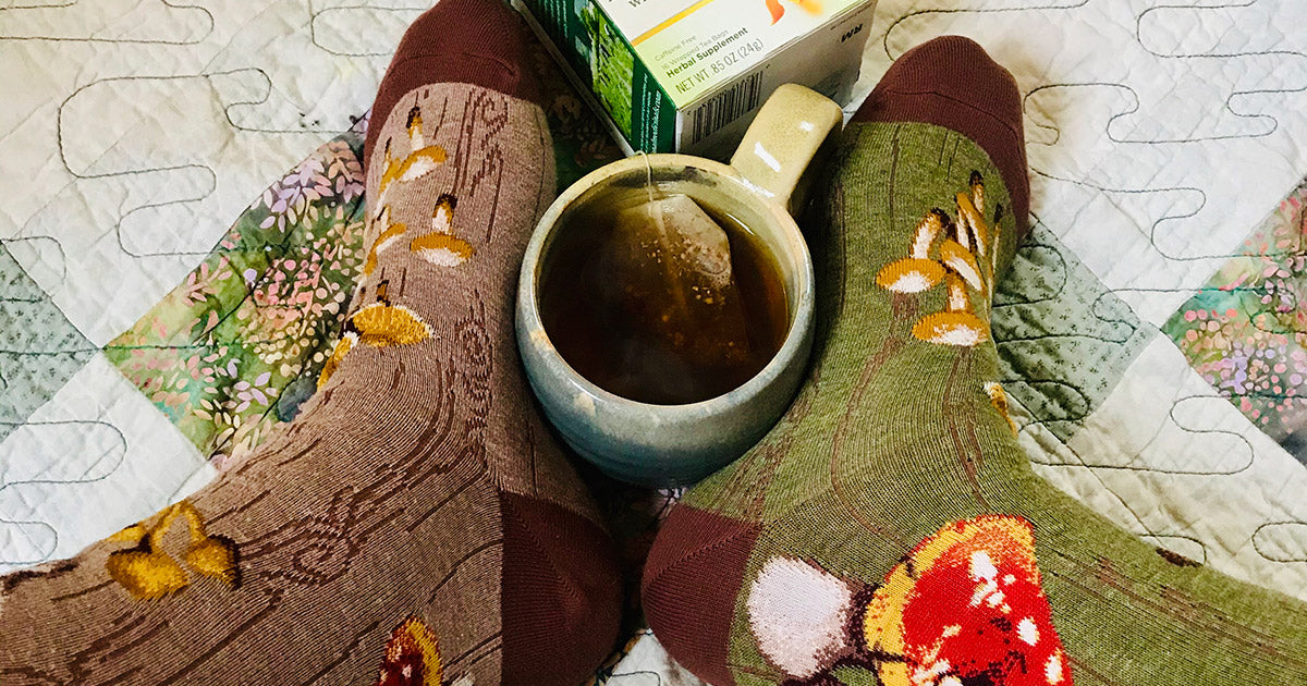 Mushroom socks and a cup of tea remind us to improve our foot wellbeing with foot wellness tips