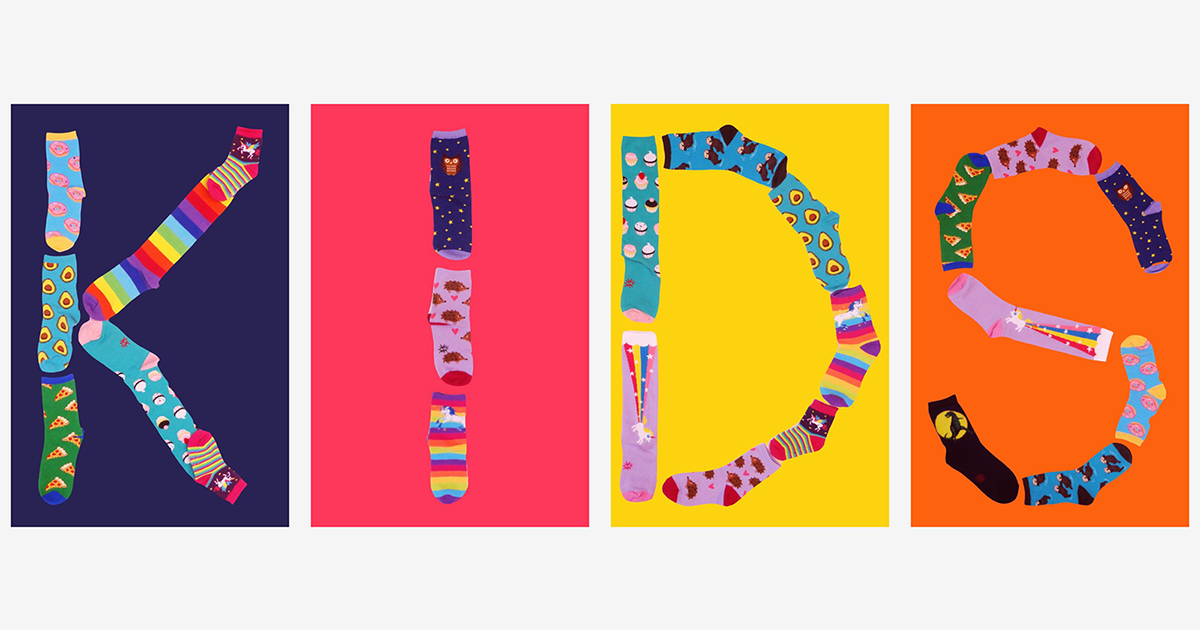 Fun back-to-school socks for kids spell out the word "KIDS."