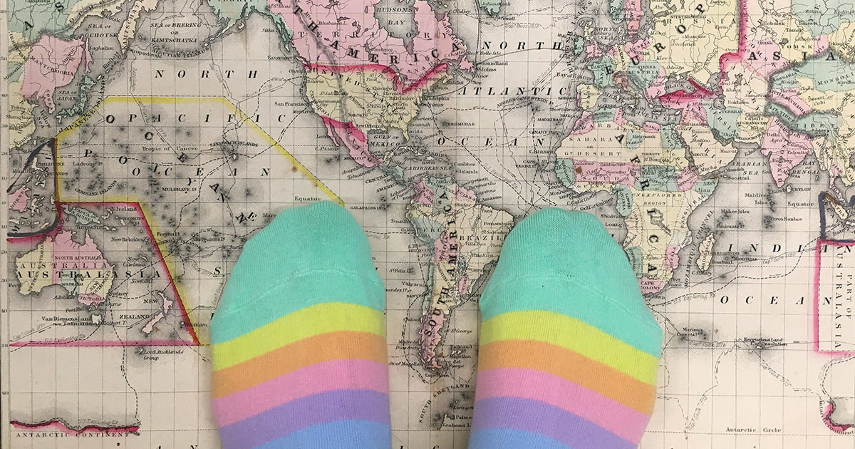 worldwide shipping illustration with pastel rainbow socks on a world map