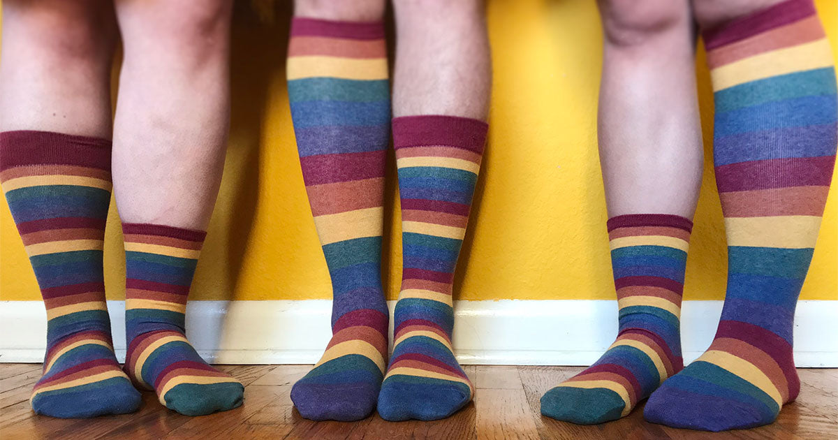Muted rainbow-striped socks designed by ModSocks in sizes to fit men, women & non-binary people.