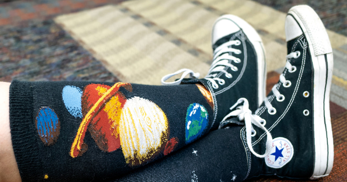 Black Converse All-Star shoes with planet socks.