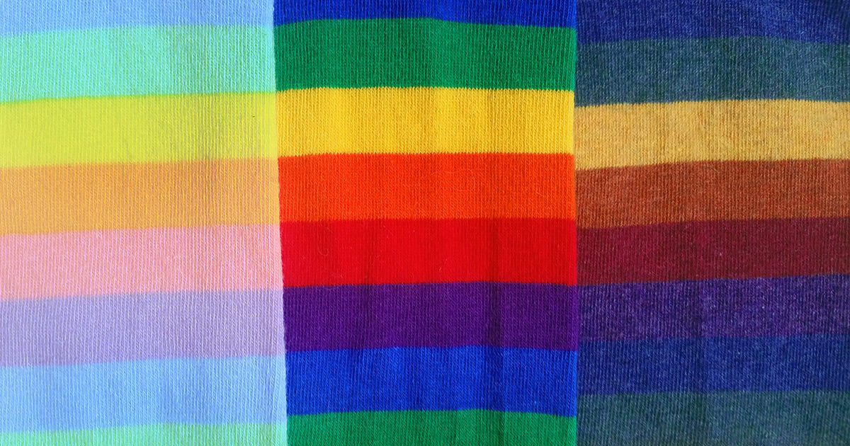 Three rainbow-striped socks in pastel, traditional and dark tones