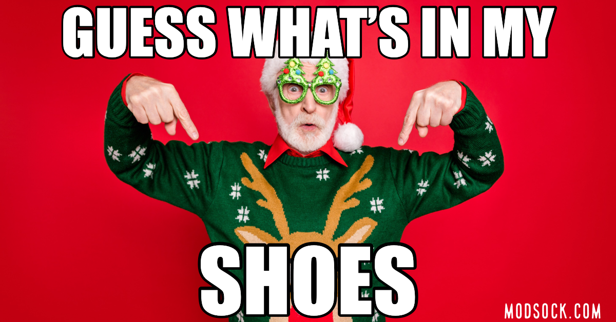 Ugly Christmas sweater meme says "Guess what's in my shoes" with man pointing to his funny Christmas socks.