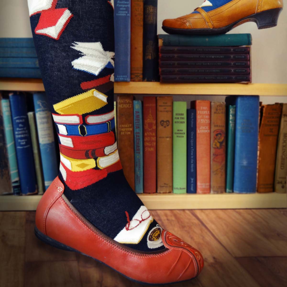 Book socks for women are black knee socks with red, yellow and blue books on them.