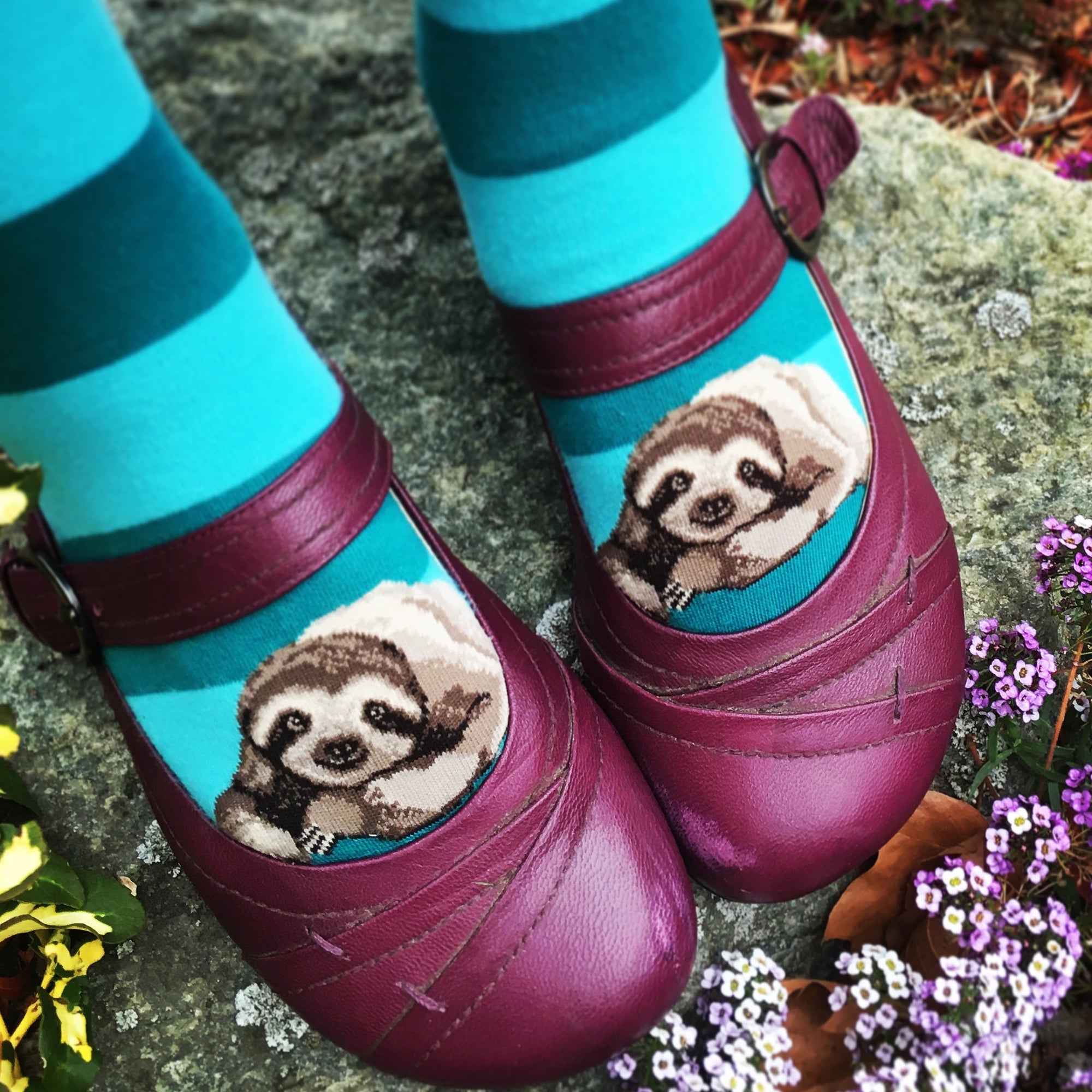 These cute teal striped sloth socks make it look like the sloths are peeking out from her purple Mary Jane shoes.