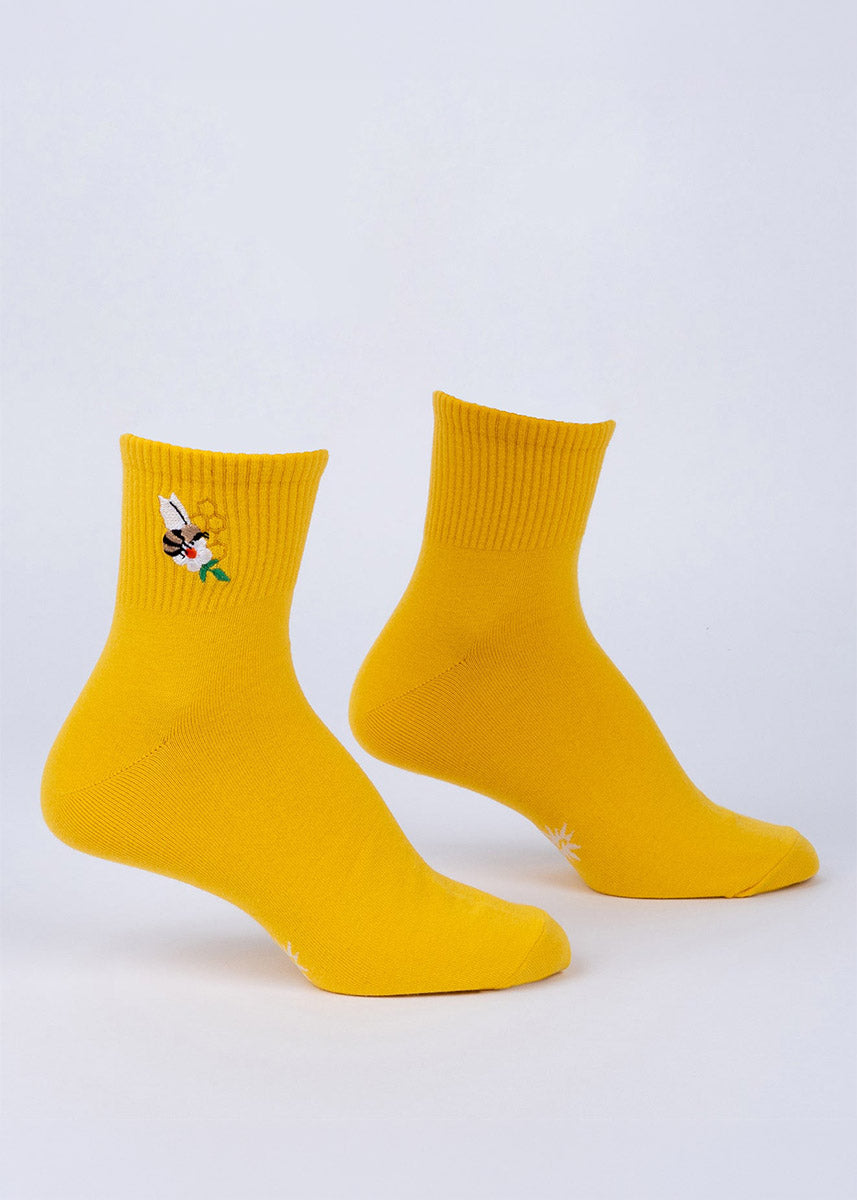Pair of yellow ribbed quarter socks with a small embroidered bee and flower design on a white background.