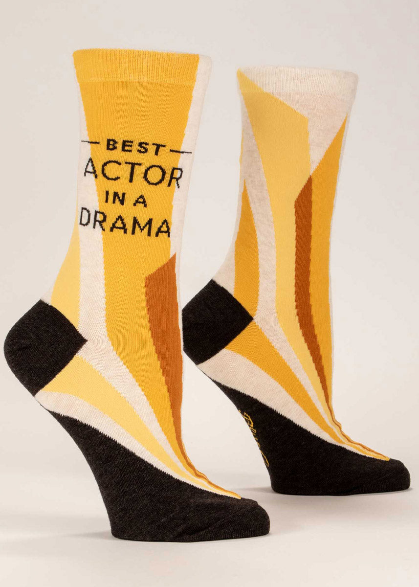 Women's crew socks with “Best Actor in a Drama” on the leg, over a yellow abstract spotlight motif. 