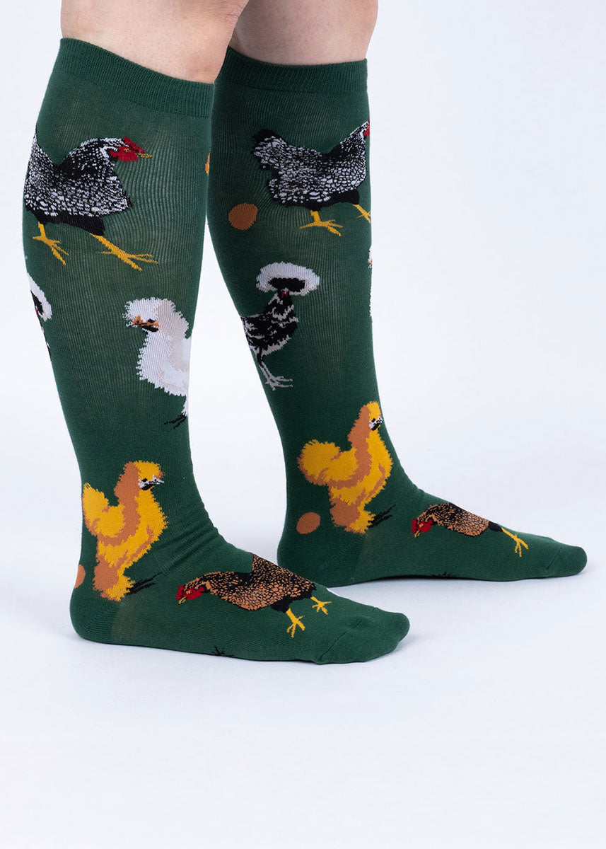 Green knee-high socks with chicken illustrations on a white background.
