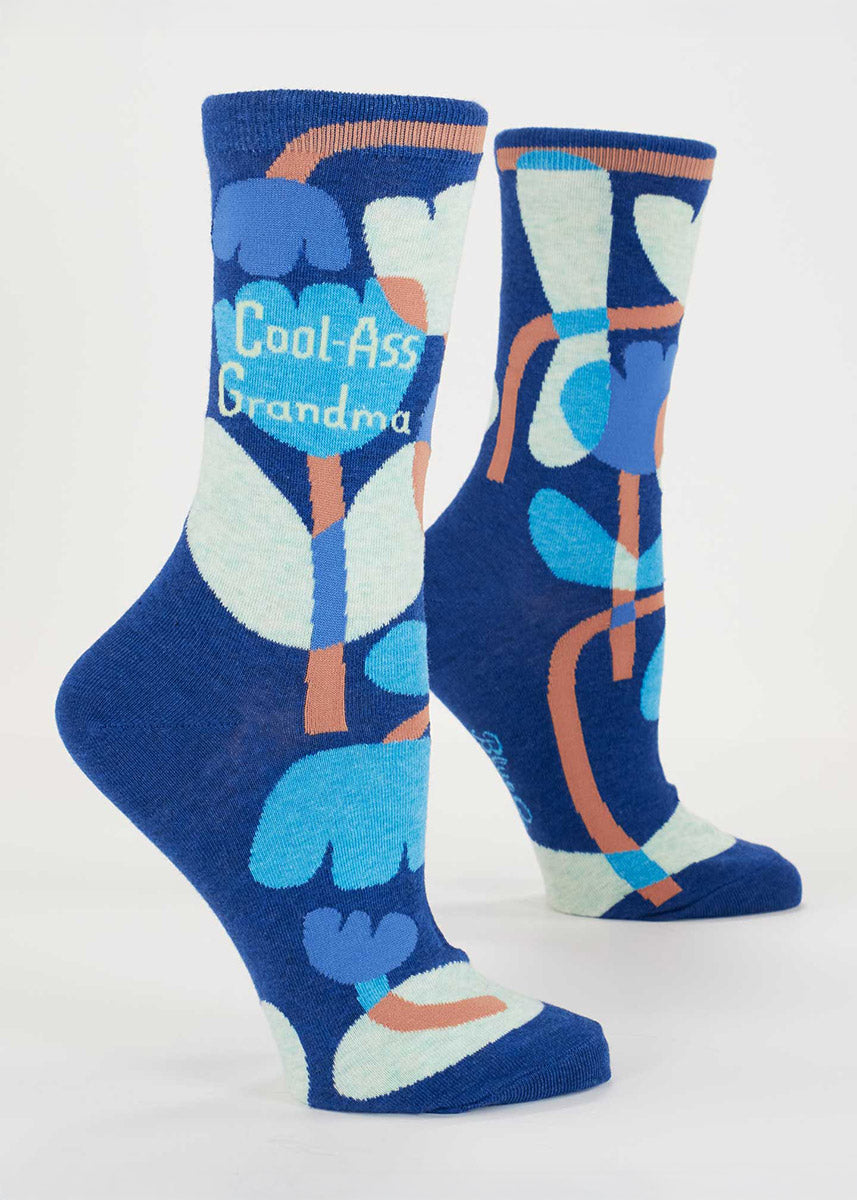 Dark blue crew socks for women with an allover abstract floral pattern in shades of blue and light brown and the words "Cool-Ass Grandma."