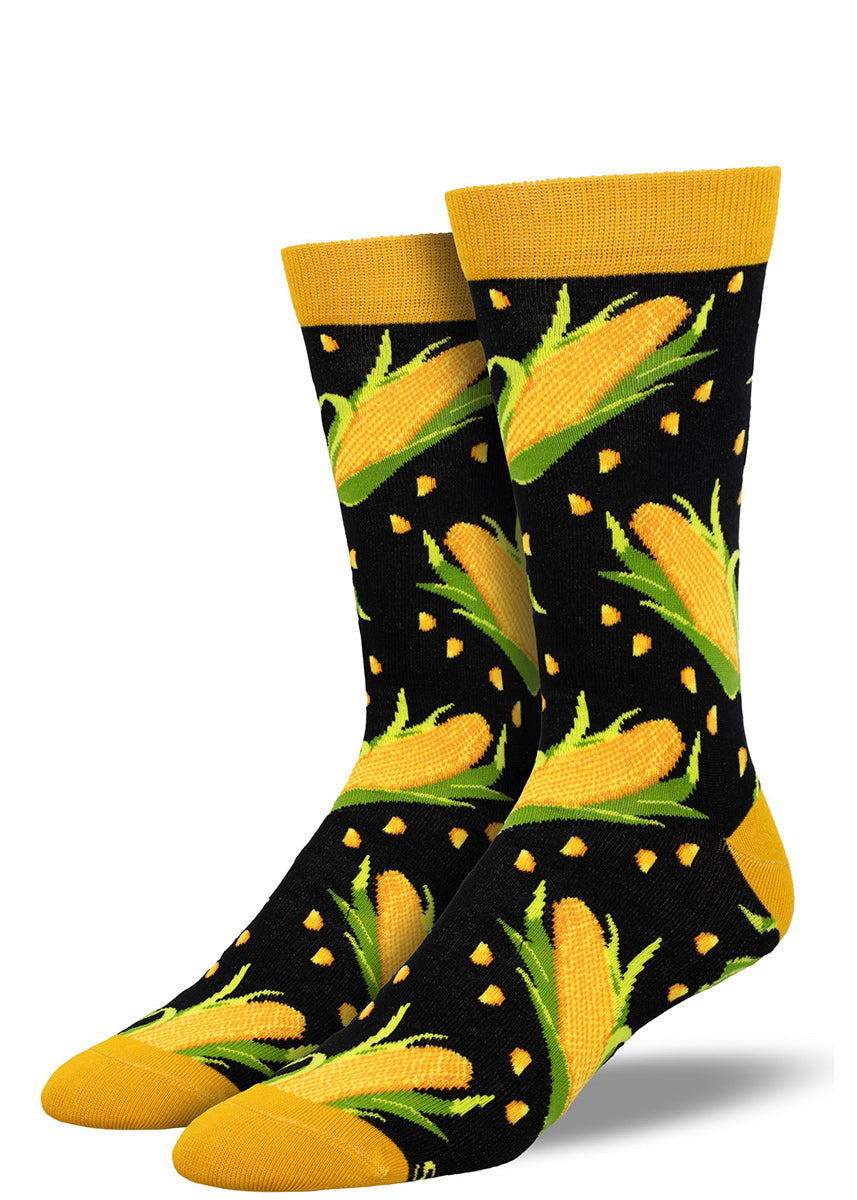Black crew socks for men with a yellow cuff and toe with an allover pattern of yellow corn on the cob and corn kernels.