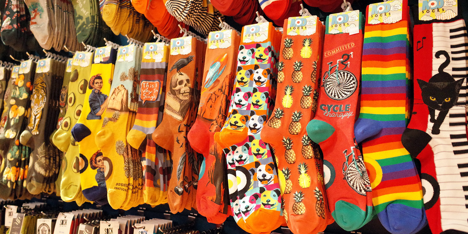 Rows of fun novelty crew socks arranged by color at Cute But Crazy Socks in Bellingham, Washington. 