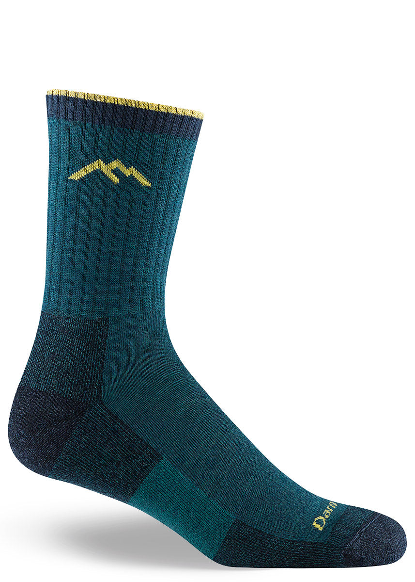 Dark teal hiking socks for men in crew length with a thin light yellow stripe at the cuff.