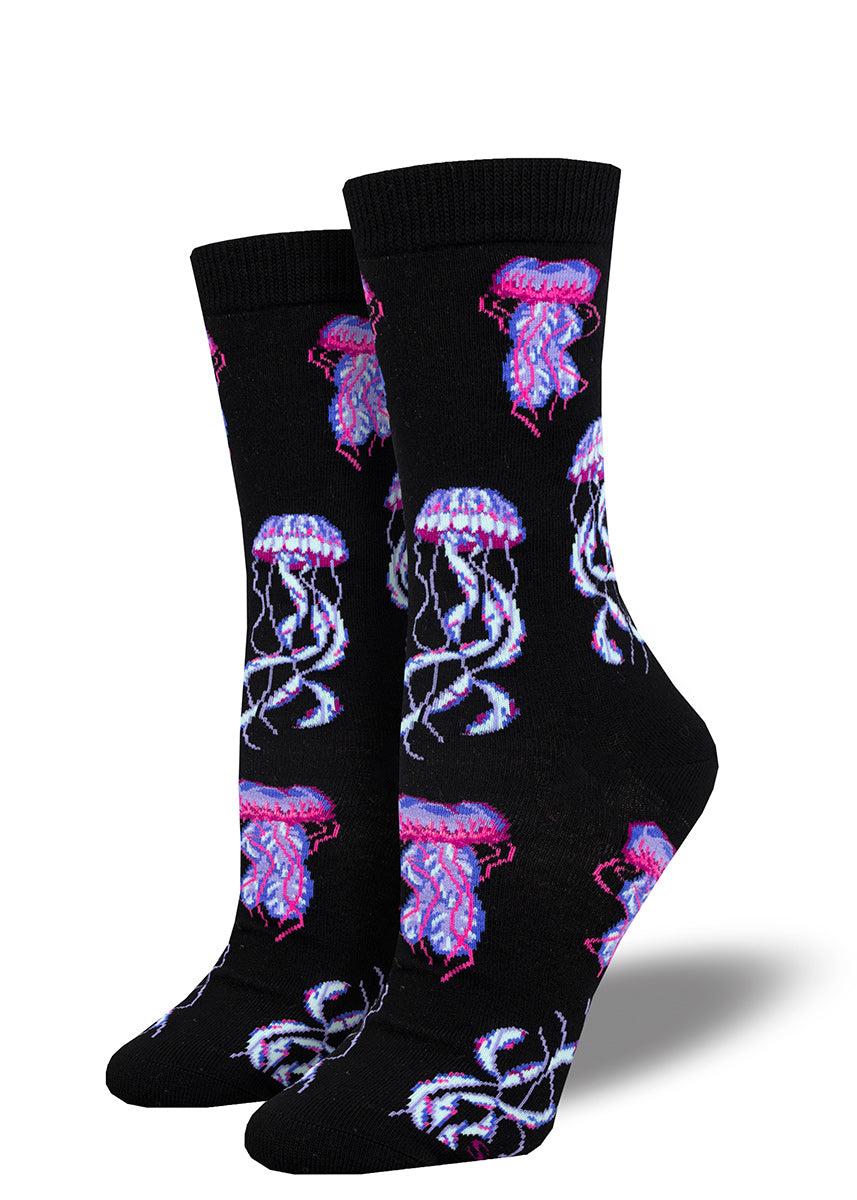 Black crew socks for women featuring an allover pattern of bright purple, pink, and white jellyfish.