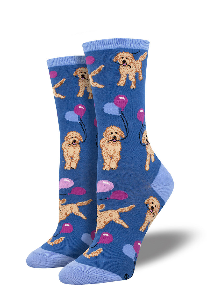 Blue socks with an allover pattern of cute Goldendoodle or Labradoodle dogs running with blue and purple balloons.