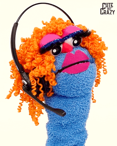 A blue drag queen sock puppet with orange curly hair wearing a phone headset.