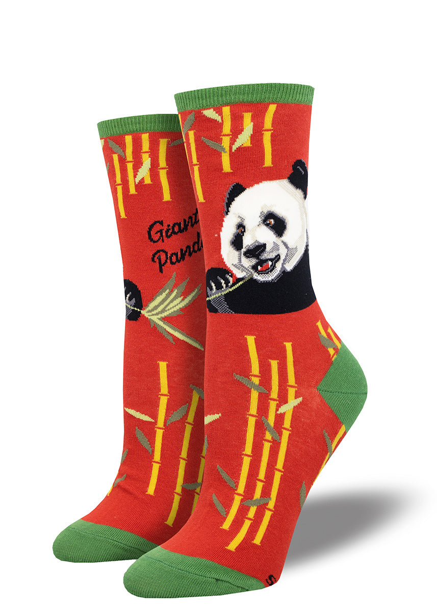 Red crew socks for women show a panda bear about to bite a bamboo shoot, with yellow bamboo stalks and leaves accenting the design. 