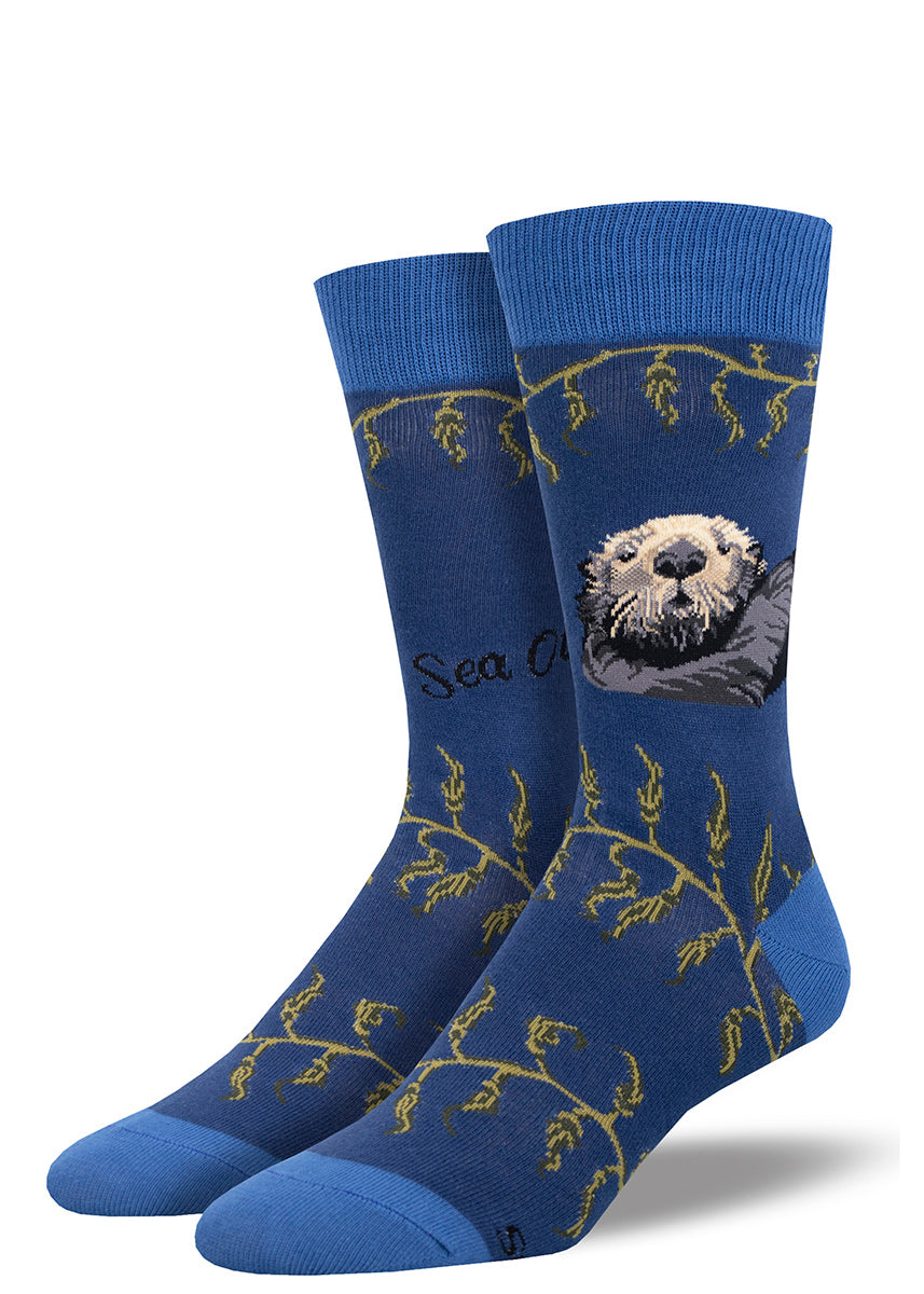Blue men's crew socks with the portrait of a sea otter and stripes of green kelp.
