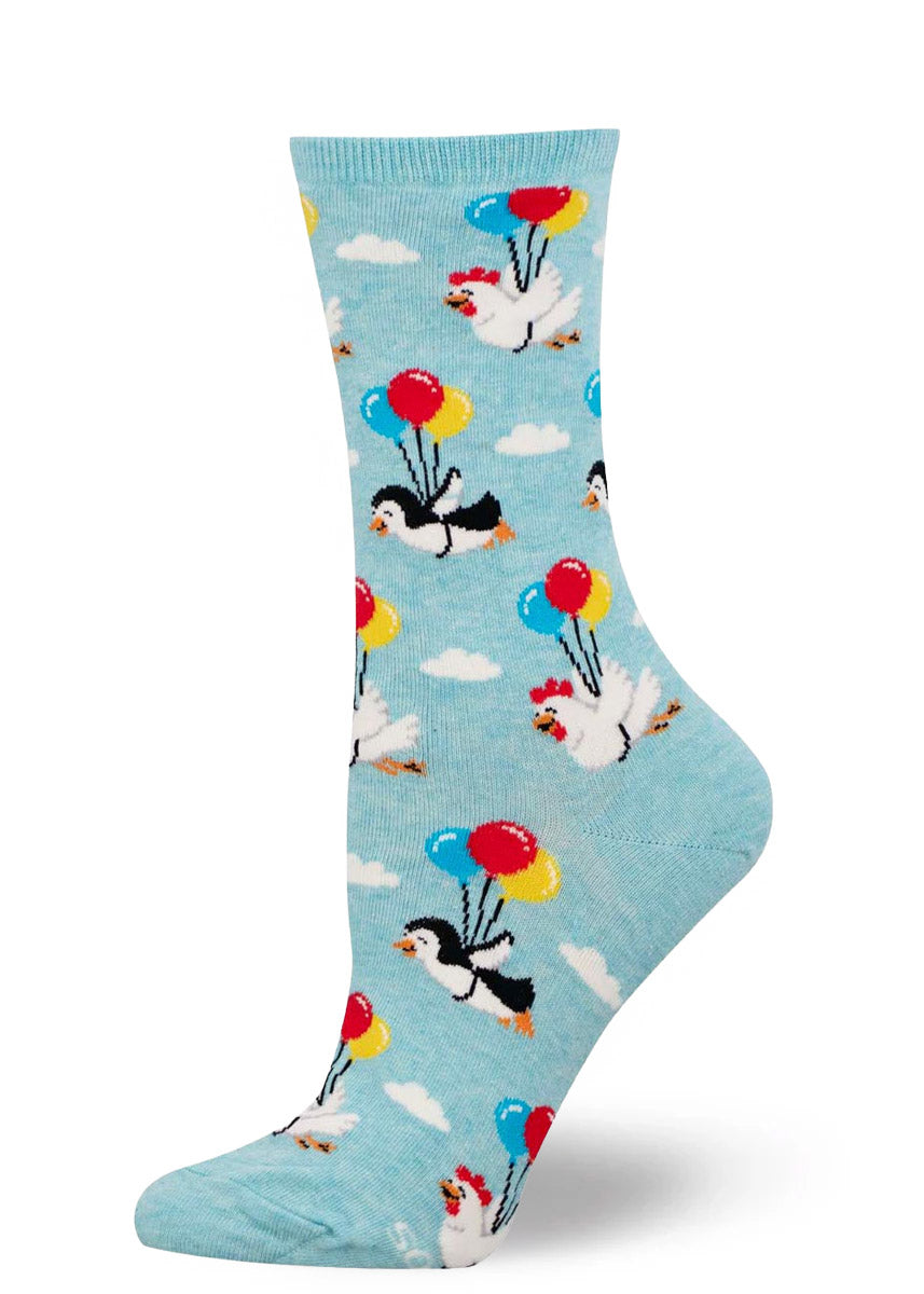 Light blue women's crew sock with a pattern of chickens and penguins with balloons on a white background.