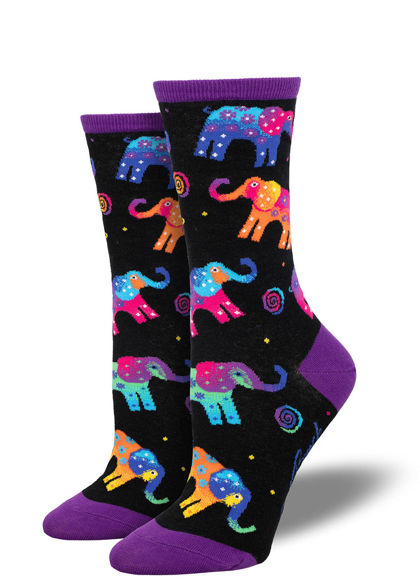 Black crew socks for women designed by the artist Laurel Burch with an allover pattern of colorful elephants with a floral pattern on them as well as colorful swirls and dots.