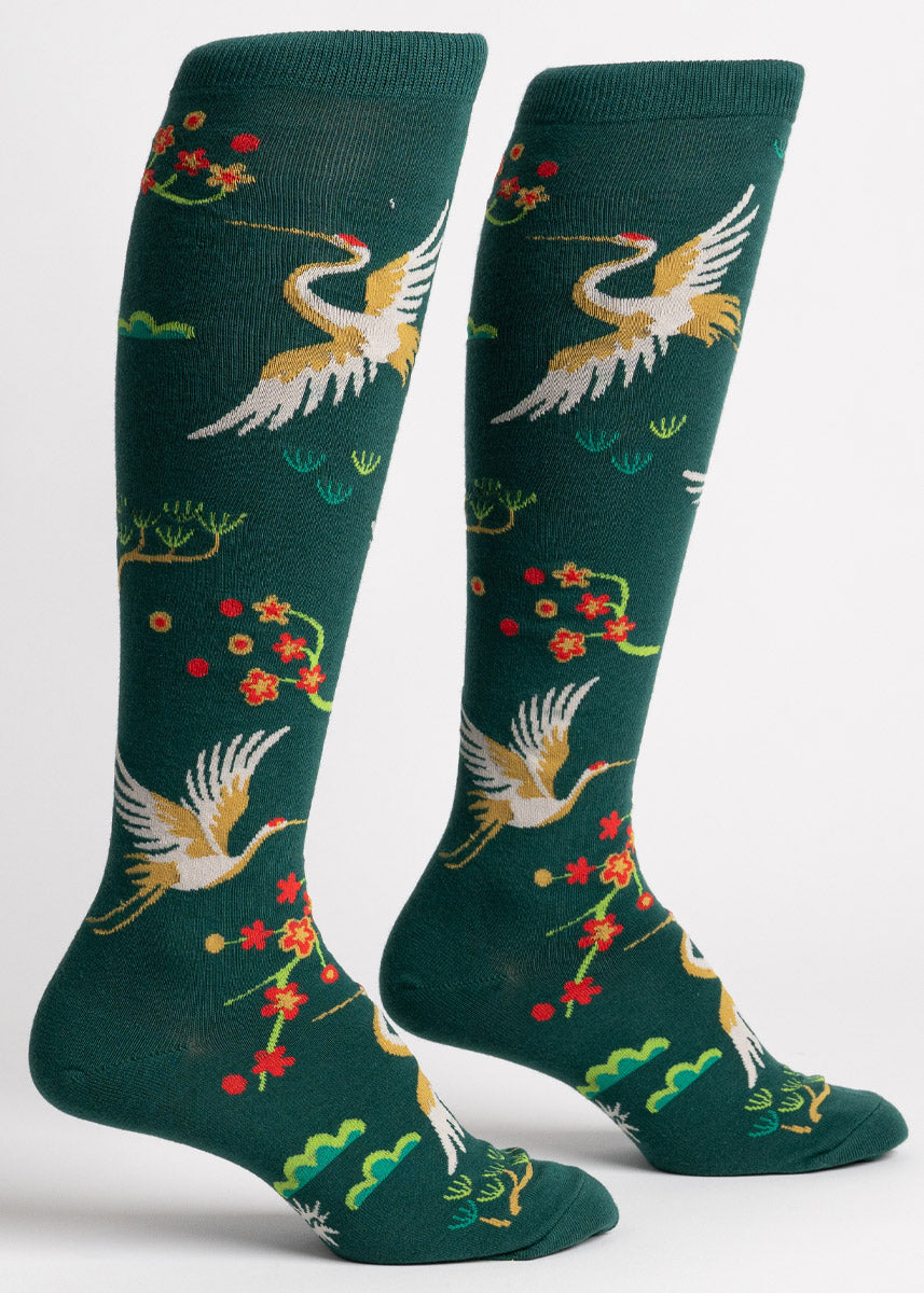 Dark green knee socks for women with a pattern of red-crowned cranes, as well as japanese cherry blossoms and other nature designs. 