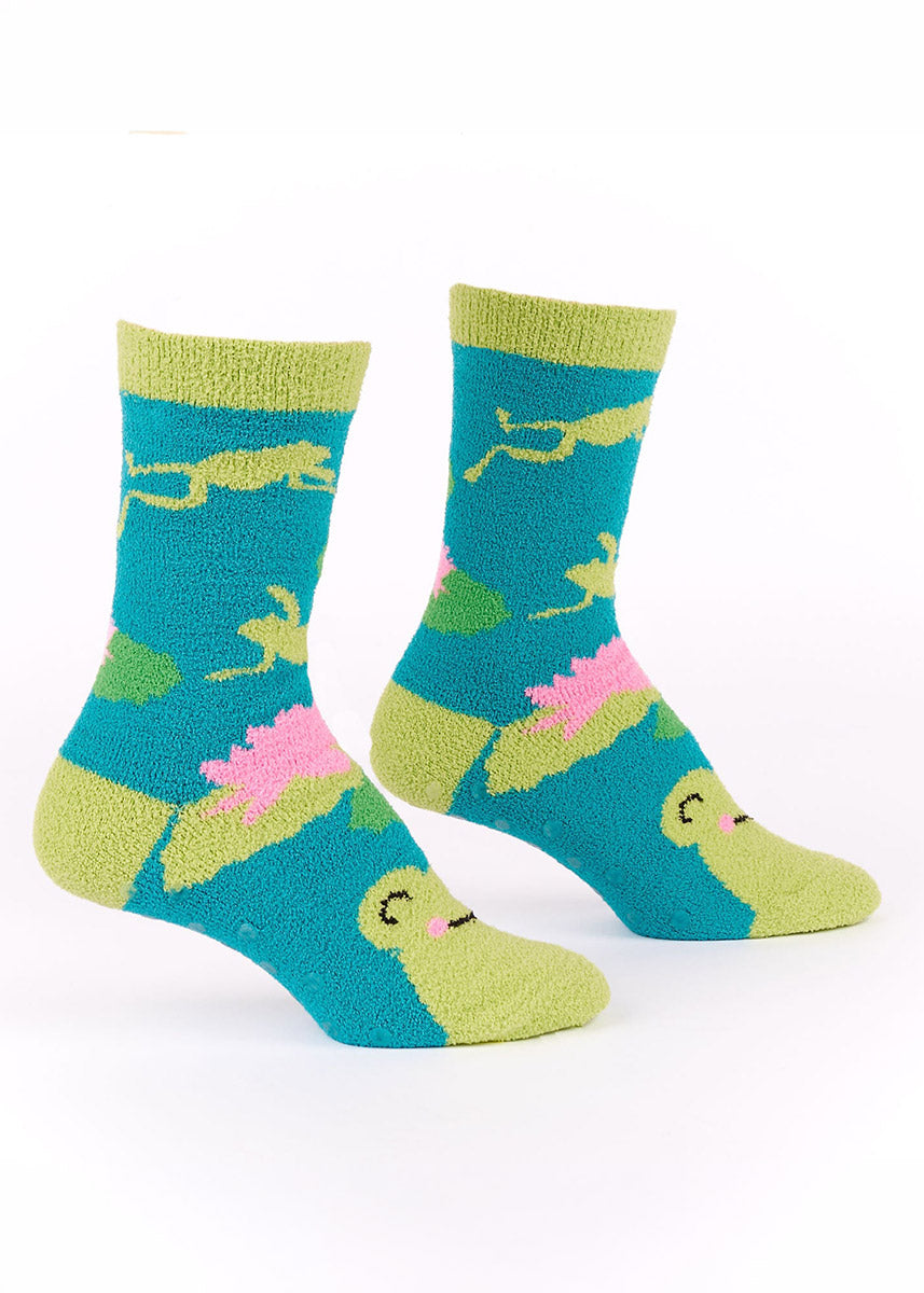 Fuzzy blue socks with frog and lily pad design on a white background.