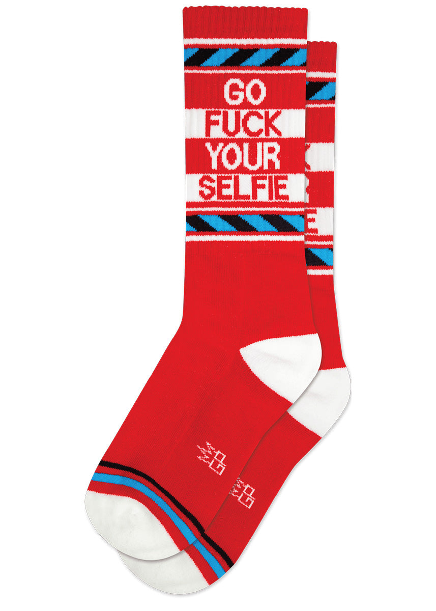Red retro gym socks with blue and white stripes and the phrase “GO FUCK YOUR SELFIE" on the leg.