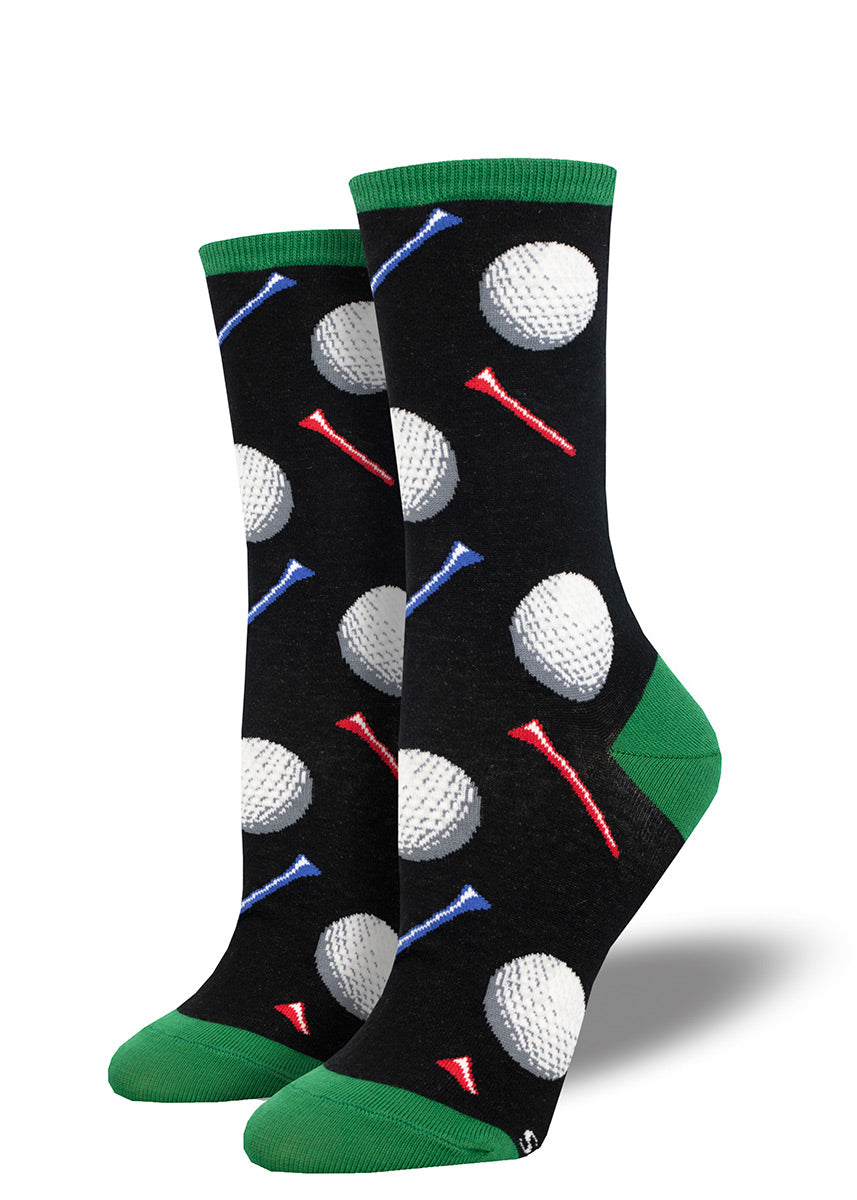 Golf socks for women with golf balls and golf tees, with a black background.