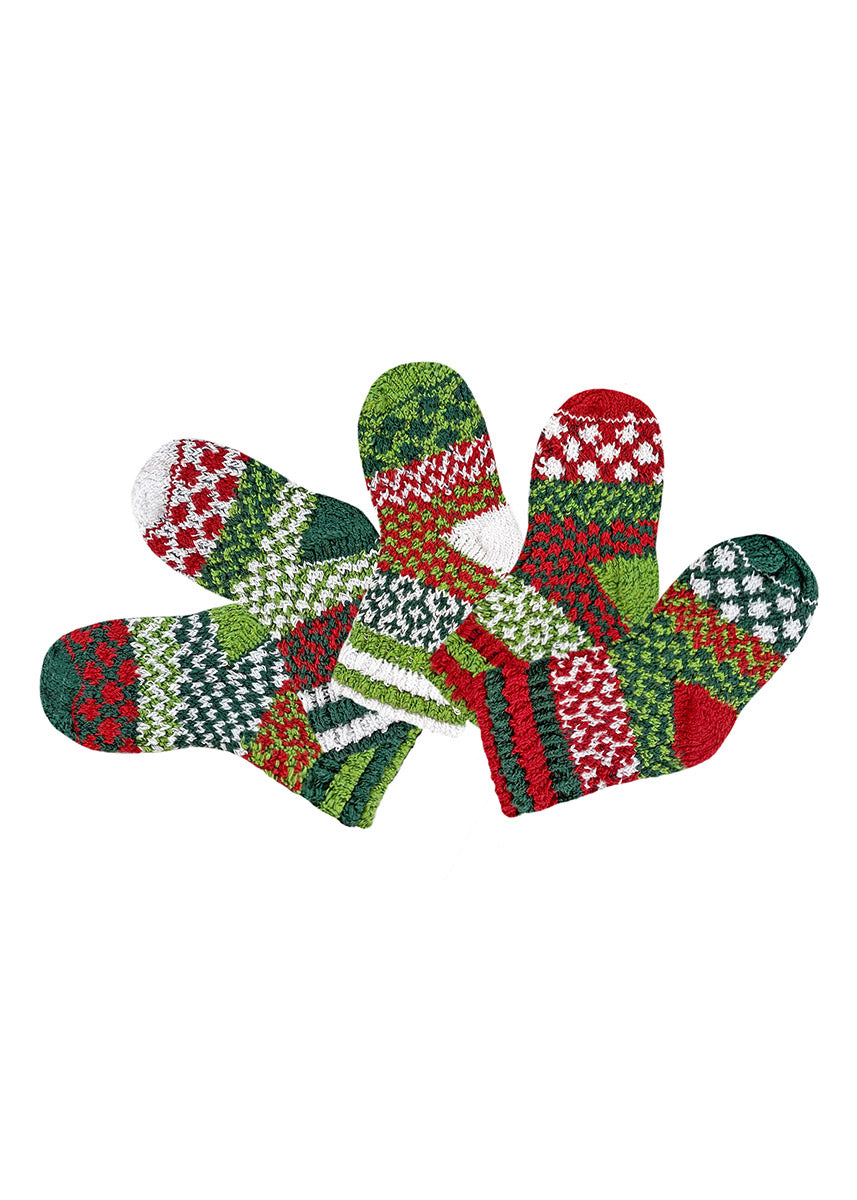 A flat lay of five different intentionally mismatched holiday crew socks for babies with different sections featuring various geometric patterns like stripes and dots in shades of red, green, and white. 